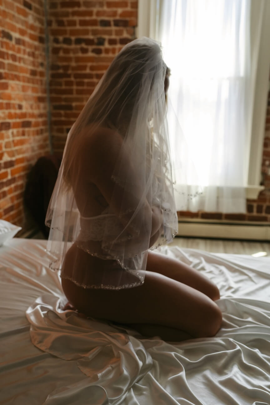 Bride wearing veil during boudoir session